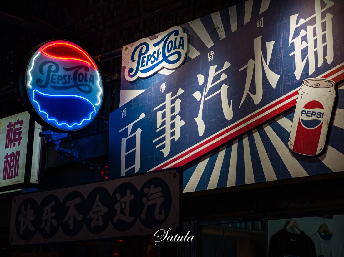 夜色中，老街立面上的百事可乐霓虹招牌。