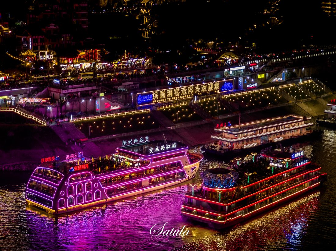 夜色里，游船灯光映亮滨水码头。