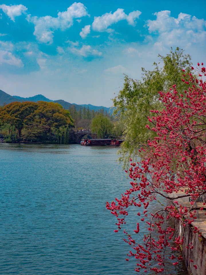 湖面、山色与岸边的红色枝叶